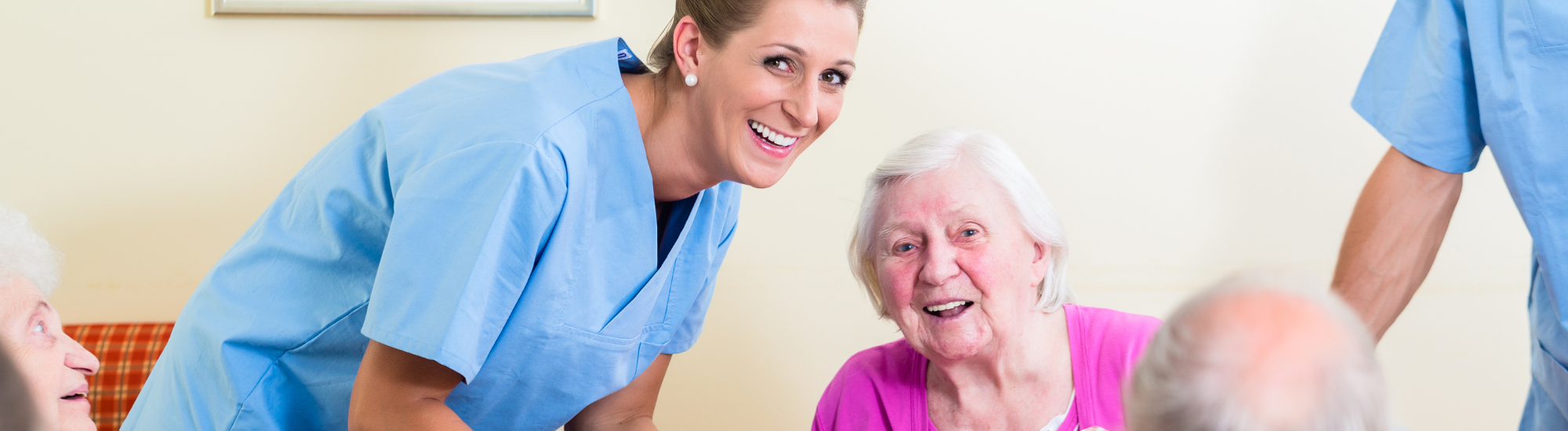 A nurse and an elderly lady are smiling. 